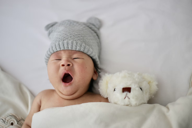 yawning baby with teddy